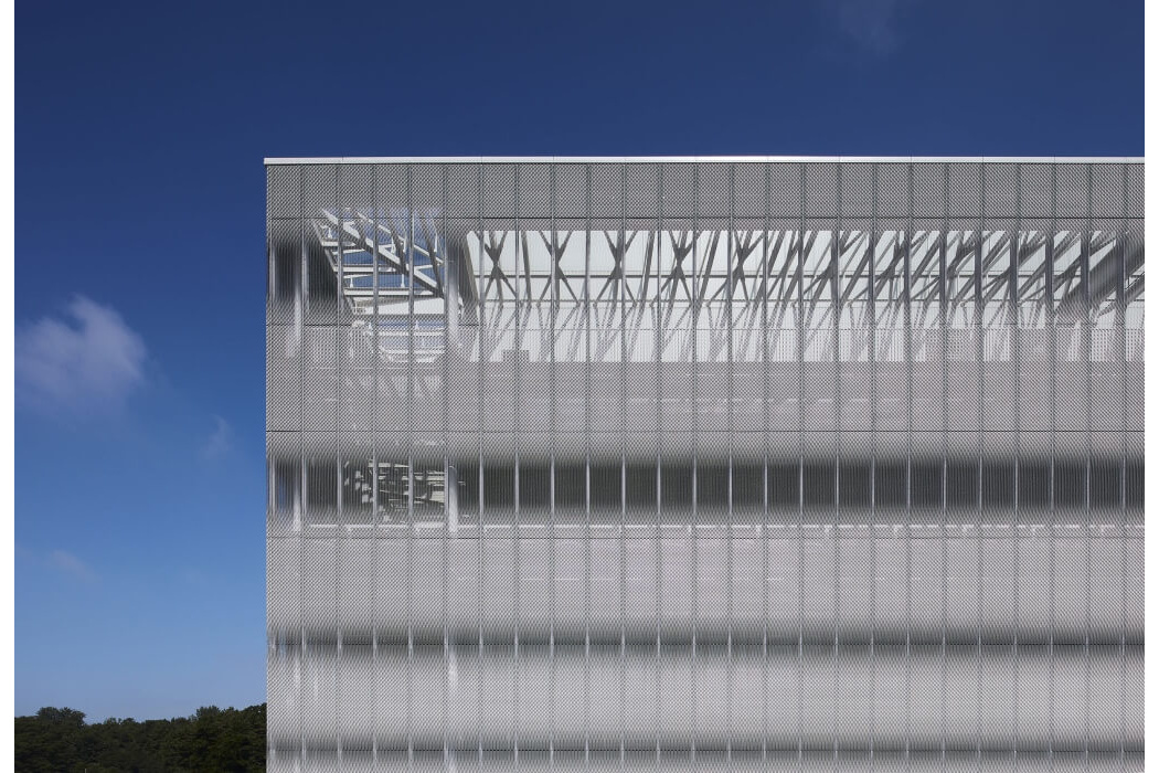 Mesh facade corner against a deep blue sky