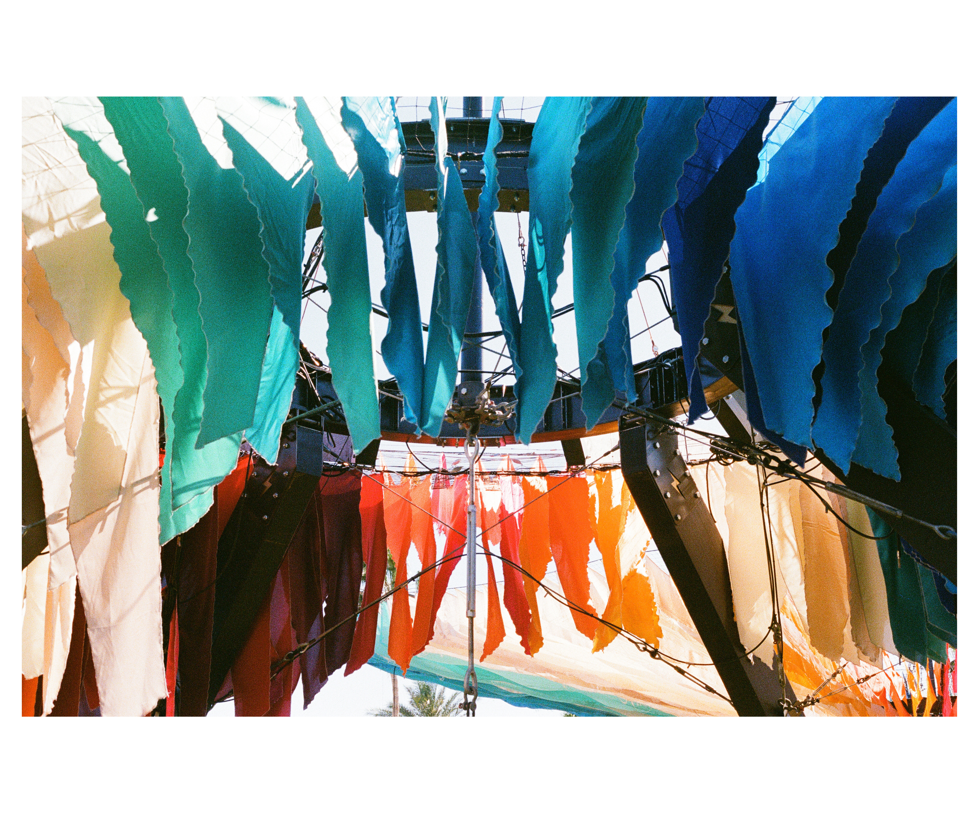 Colored fabric strips hanging from the steel ring at the canopy's center