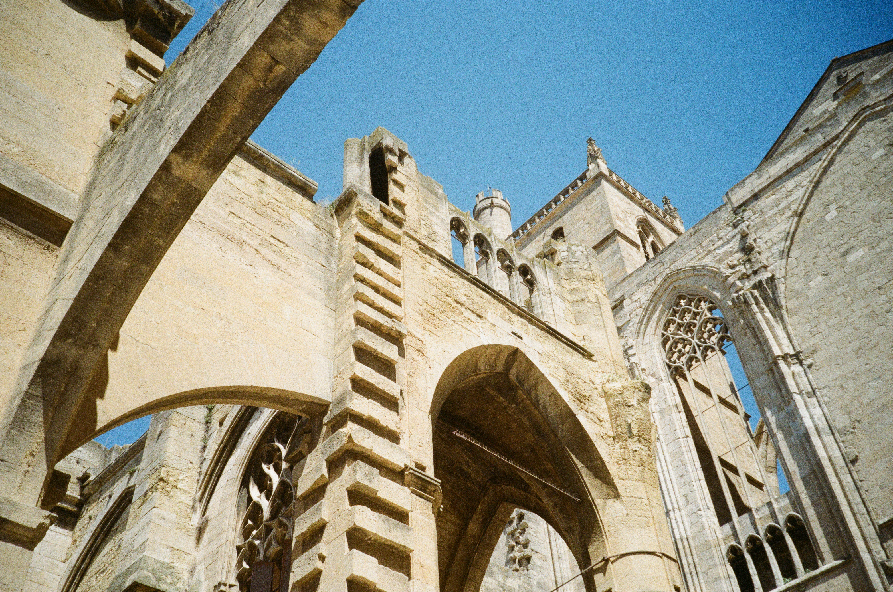 Ruined Gothic cathedral arches against a blue sky