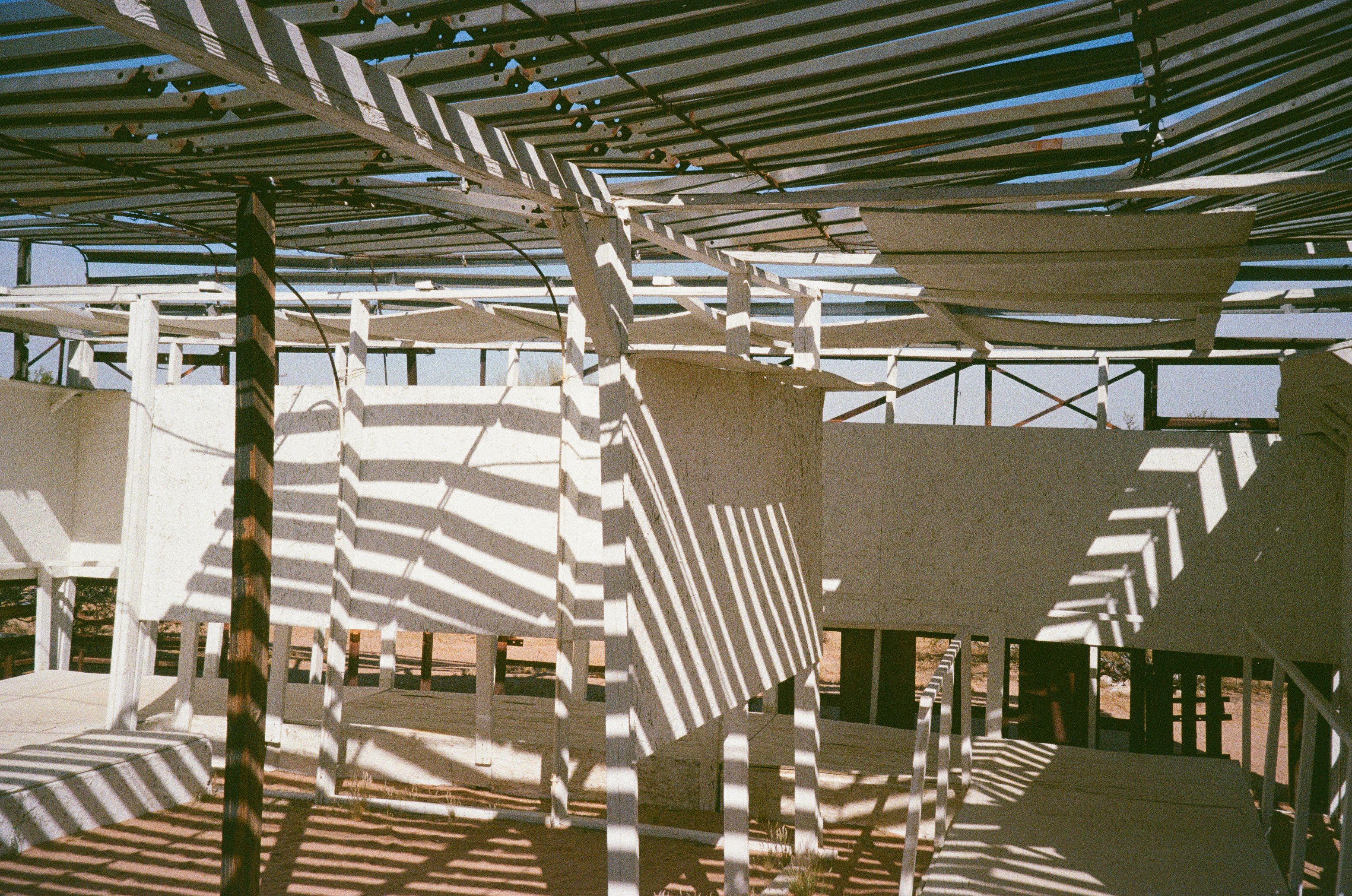 Striped shadows through a white timber structure