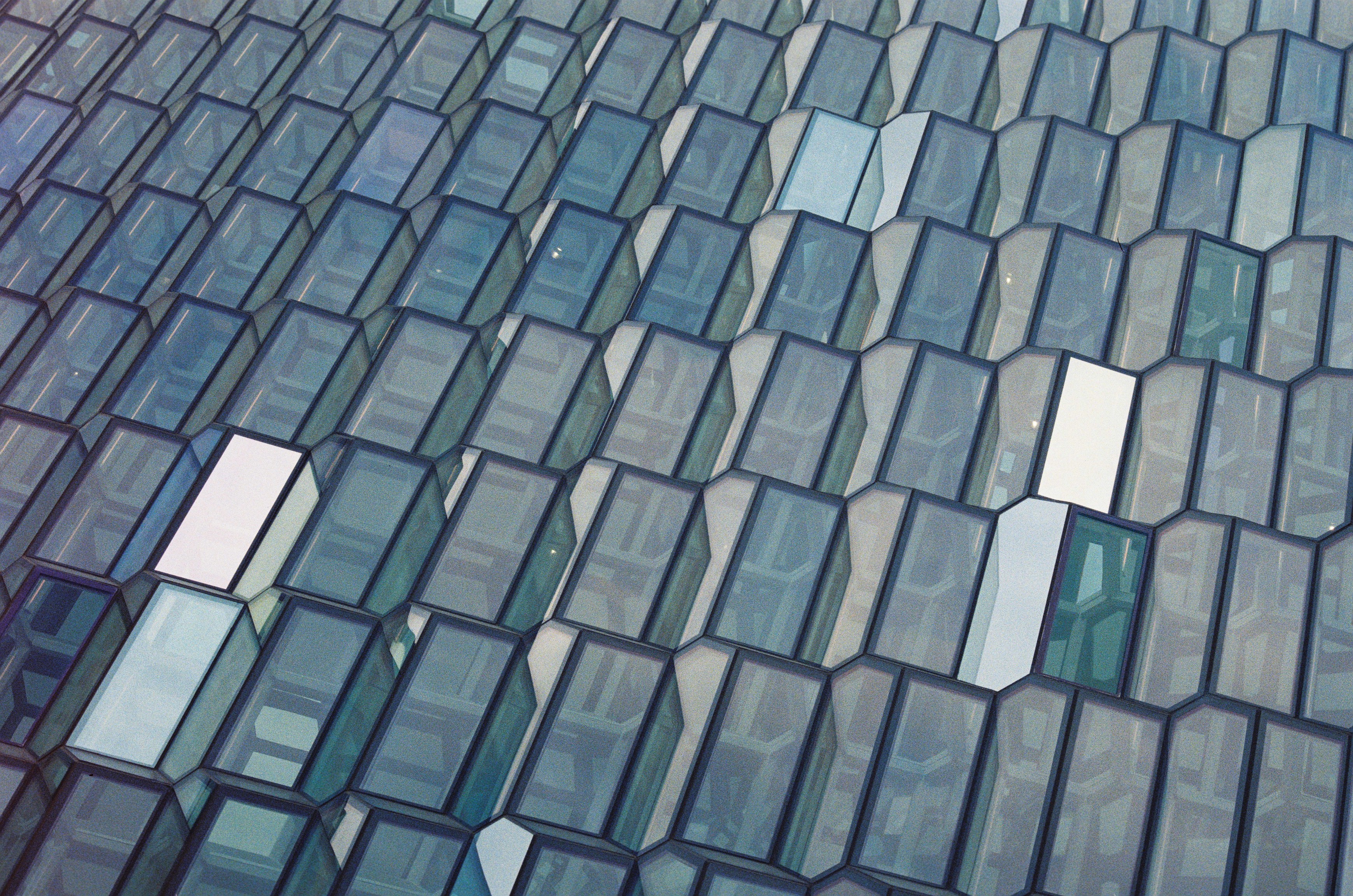 Close-up of a faceted glass façade in blue and green